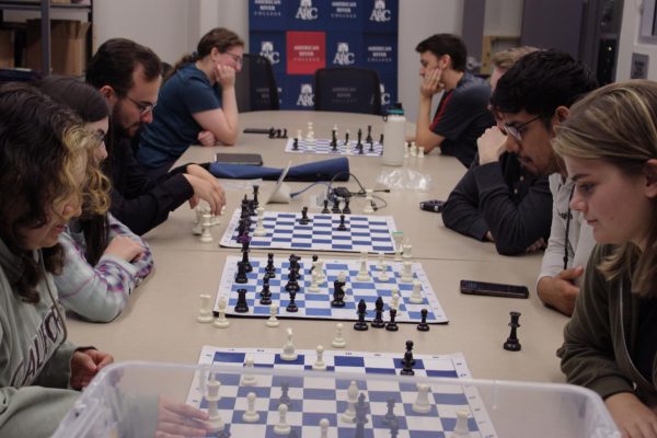 Members of the Chess Club play during a meeting on Oct. 29, 2024. Club president (third to the left) playing chess with the club's treasurer. (Photo by Carter Chitiva)